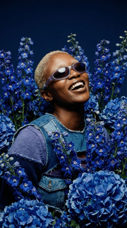 a black man with sunglasses and blue flowers