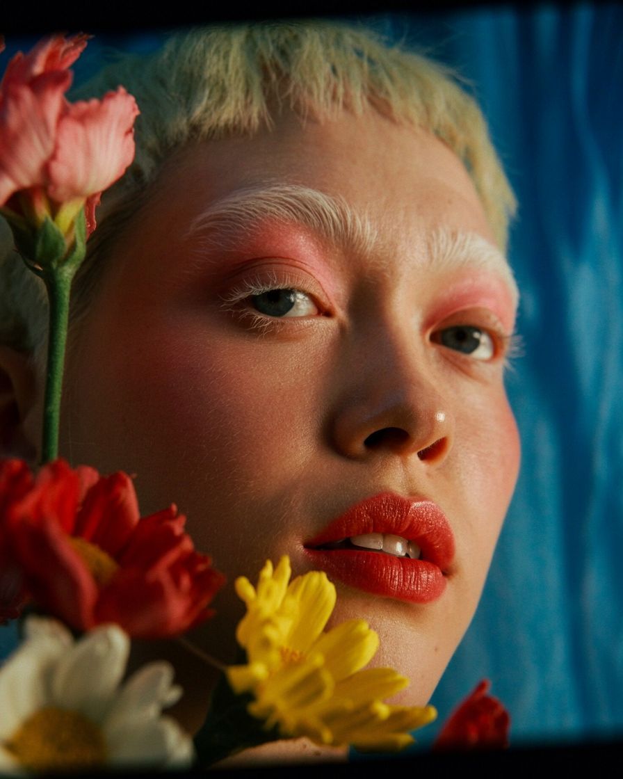 a close up of a person with flowers in their hair