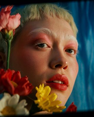 a close up of a person with flowers in their hair