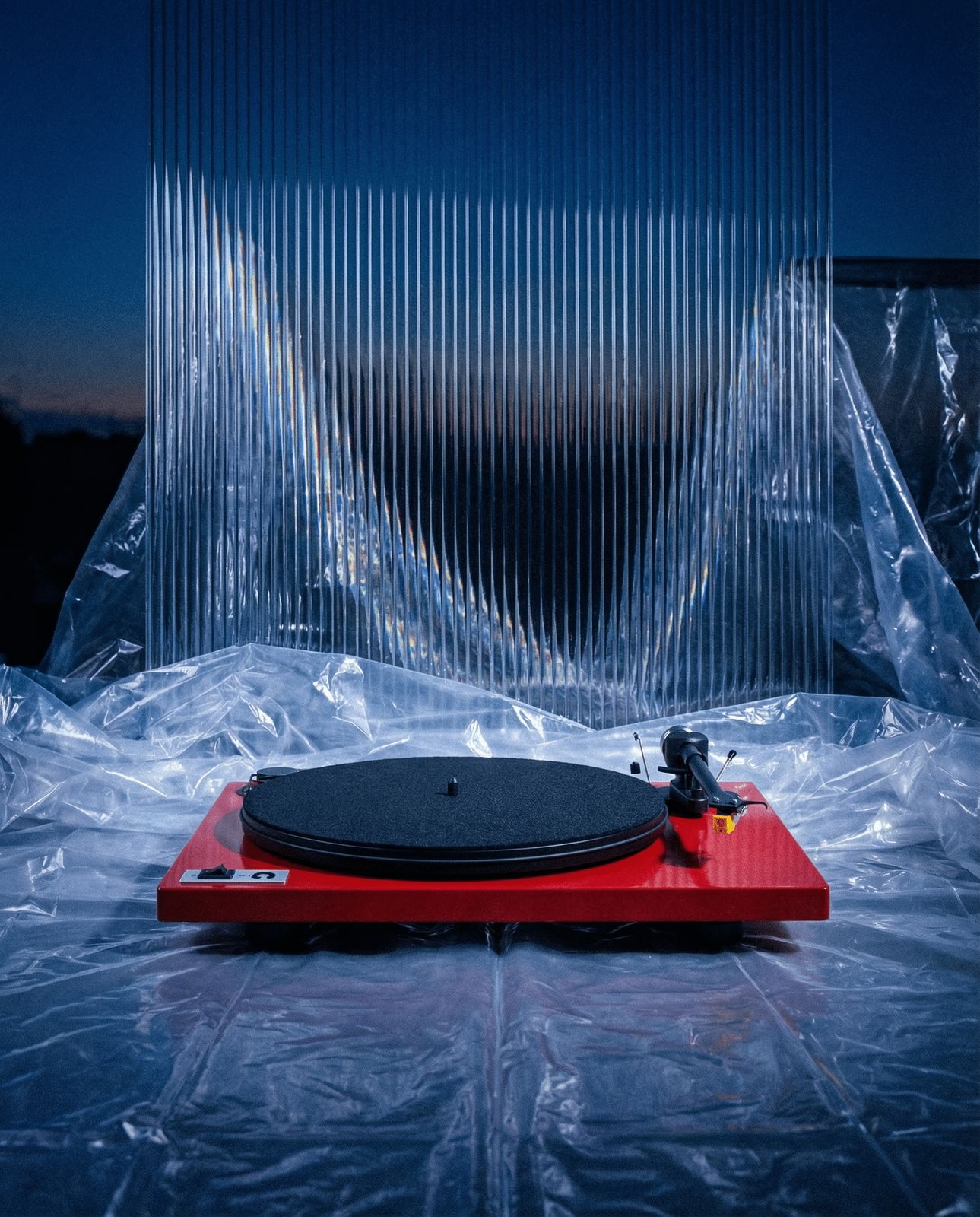 a red turntable sitting on top of a plastic sheet