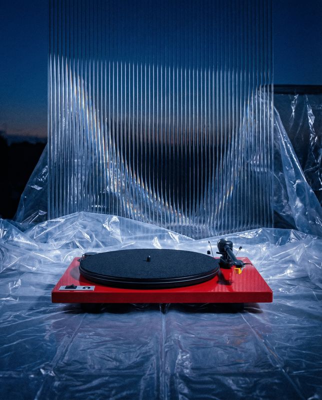 a red turntable sitting on top of a plastic sheet