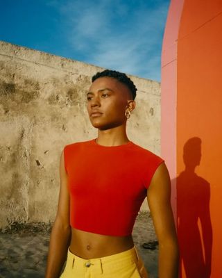 a woman standing in front of a red wall
