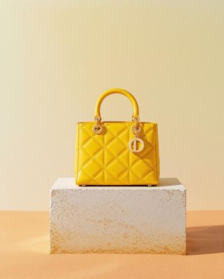 a yellow handbag sitting on top of a white block