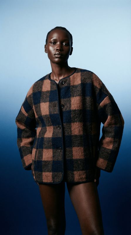 a woman in a plaid jacket and shorts