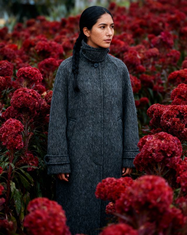 a woman standing in a field of red flowers