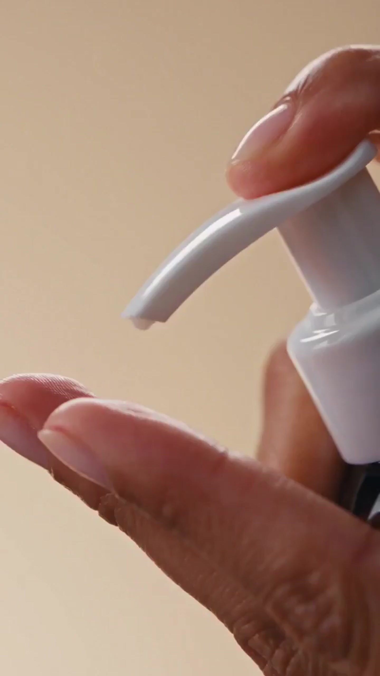a hand holding a bottle with a liquid in it