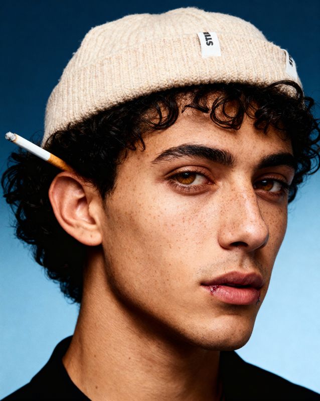 a young man with a cigarette in his mouth