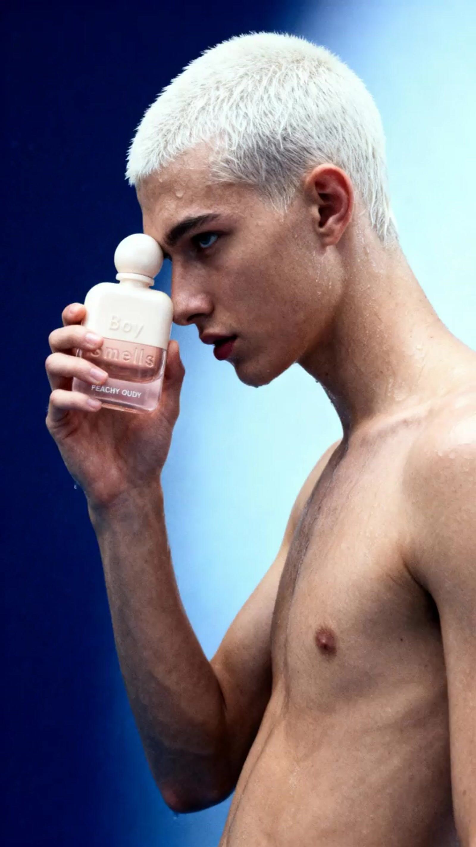 a shirtless man holding a bottle of pills