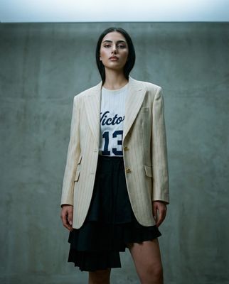 a woman standing in front of a concrete wall