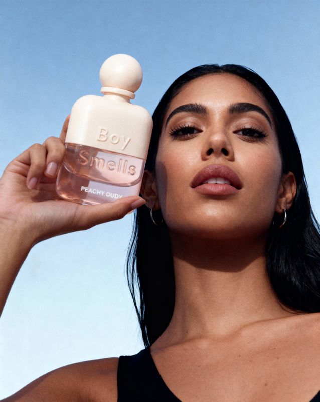 a woman is holding a bottle of perfume