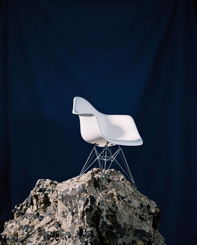 a white chair sitting on top of a rock