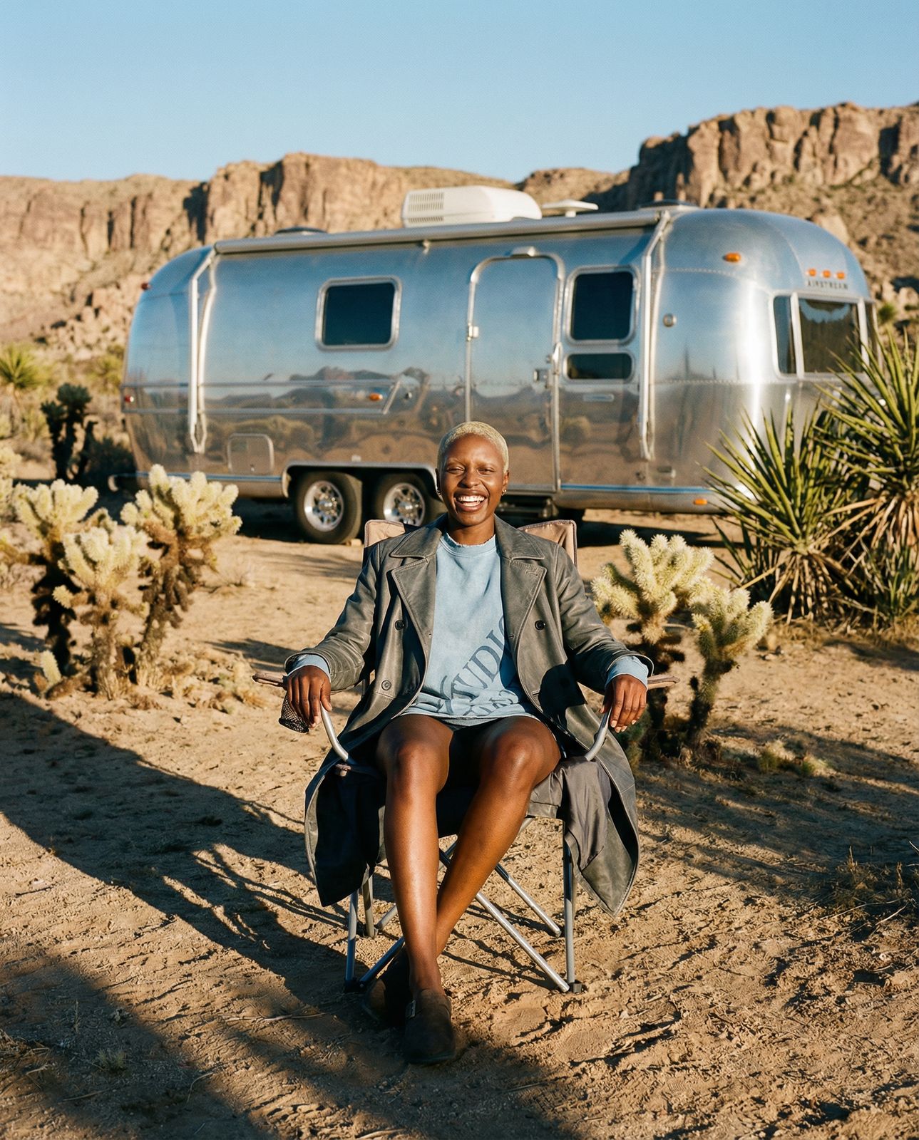 a woman sitting in a chair in front of a trailer
