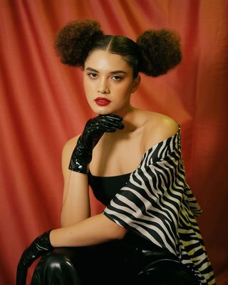a woman in a black and white top and gloves