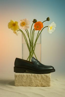 a pair of shoes sitting on top of a block of stone