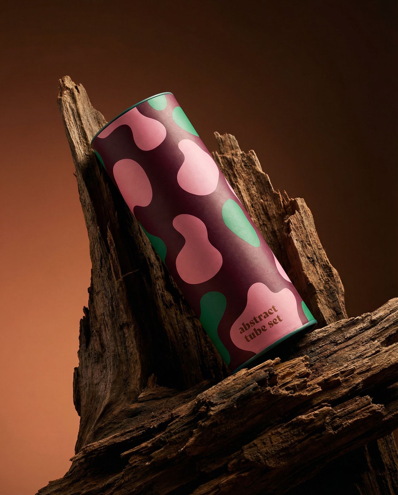 a pink and green polka dot coffee cup sitting on a piece of wood