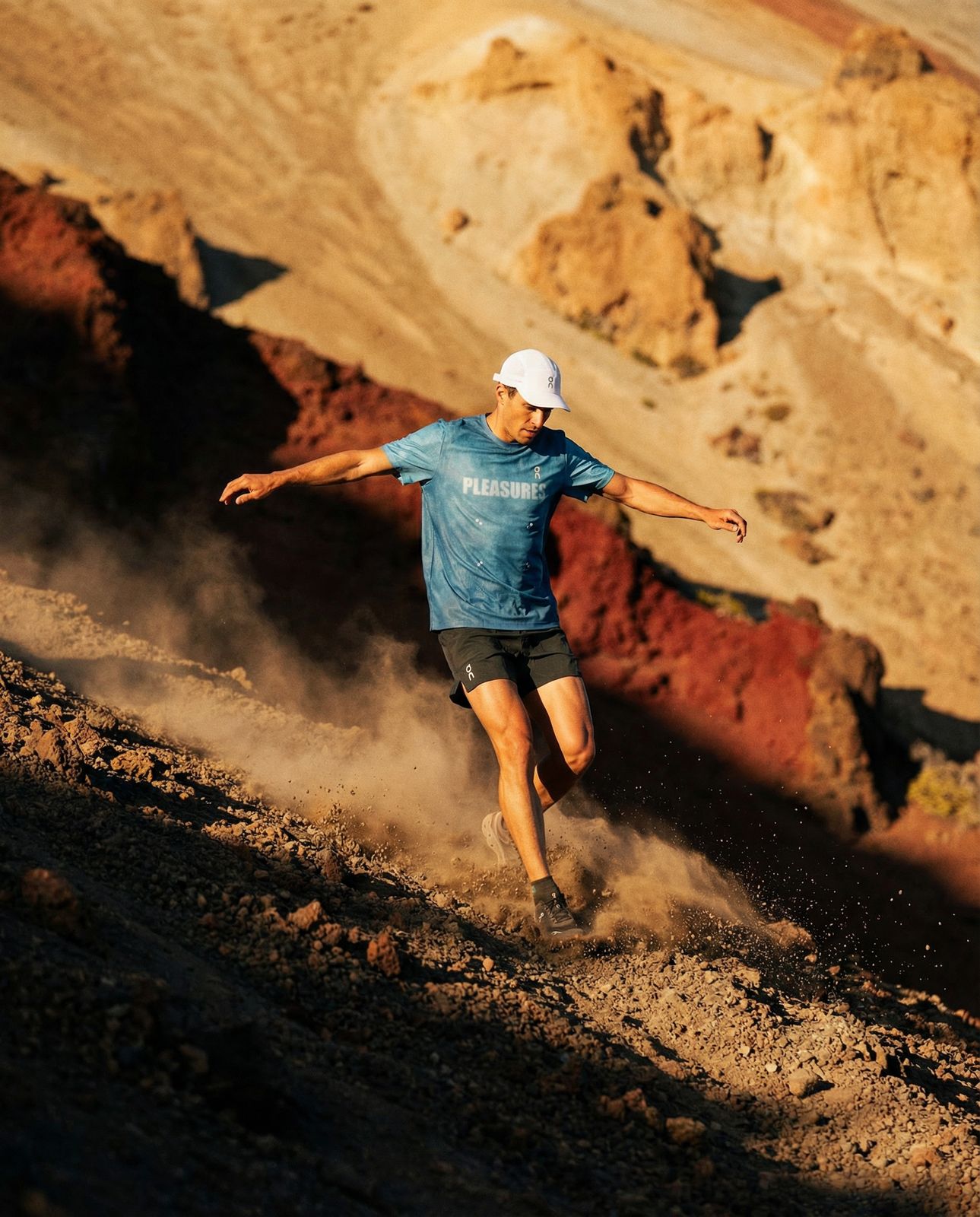 a man running up a hill in a blue shirt