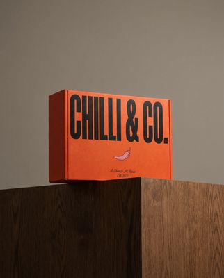 a box of chilli and co sitting on top of a wooden table