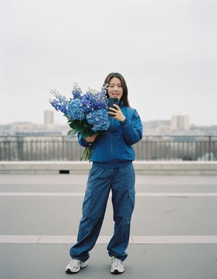 a woman holding a bunch of blue flowers