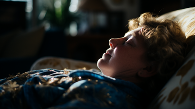 a young boy laying on a couch with his eyes closed