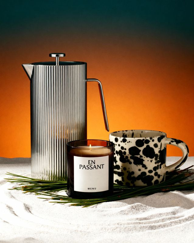 a candle and a coffee pot on a table