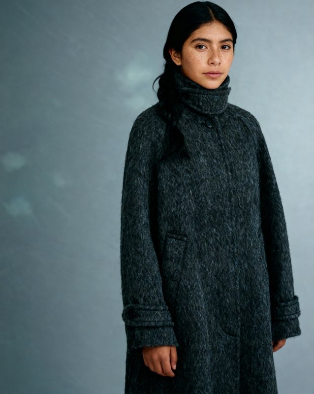 a woman wearing a black coat and a black scarf