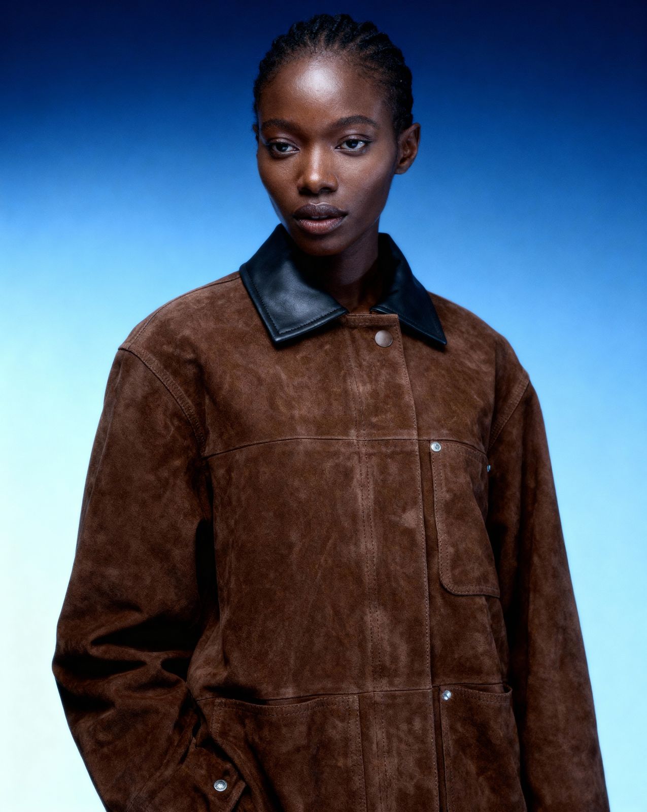 a woman in a brown jacket posing for a picture