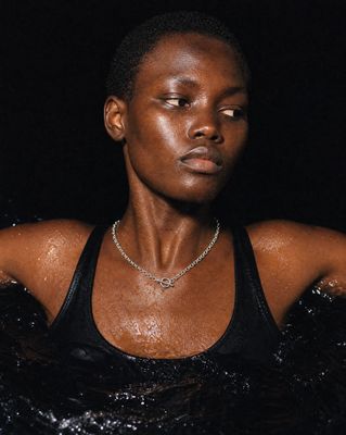 a woman in a black tank top with a diamond necklace
