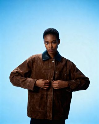 a woman in a brown jacket posing for a picture