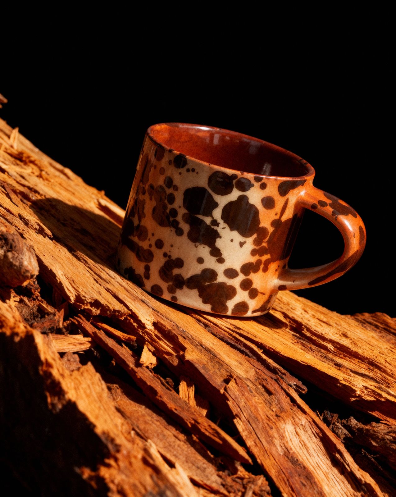 a coffee cup sitting on top of a pile of wood