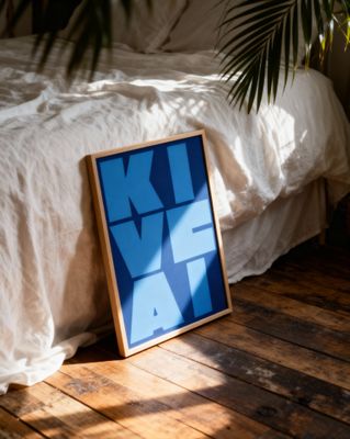 a picture frame sitting on the floor next to a bed