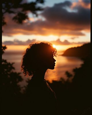 a person standing in front of a sunset