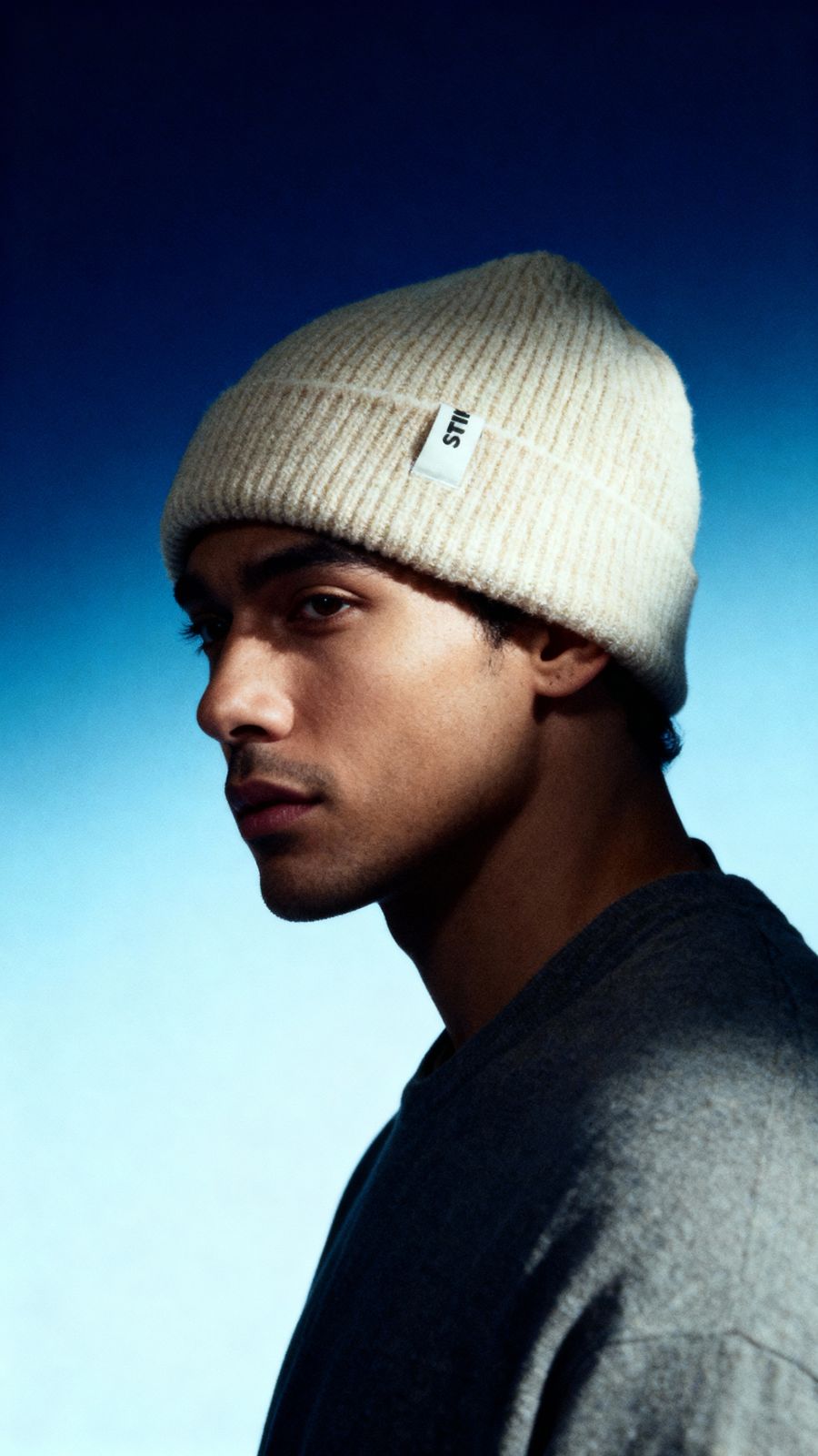 a young man wearing a beanie looking at the camera
