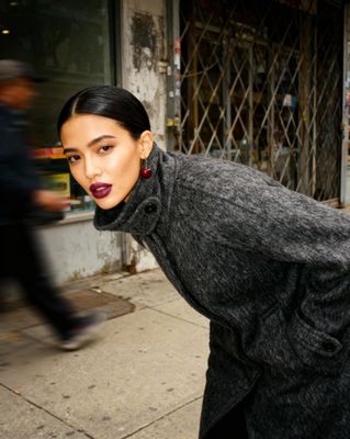 a woman in a black coat and red lipstick