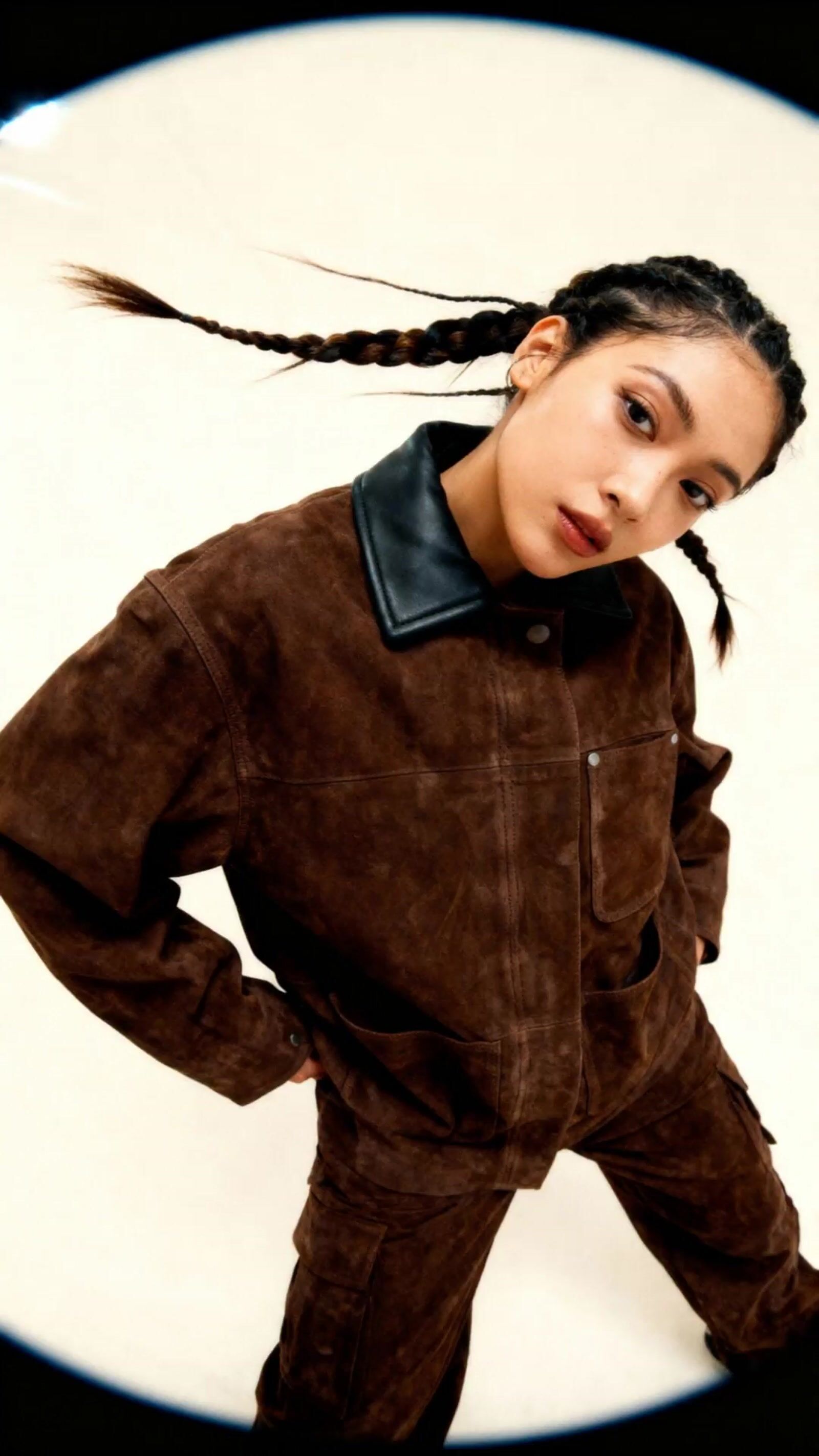 a woman with braids standing in front of a white background