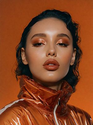 a woman wearing a shiny orange jacket