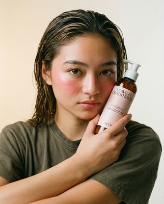 a woman holding a bottle of skin care product