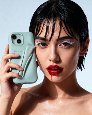 a woman holding up a cell phone to her face