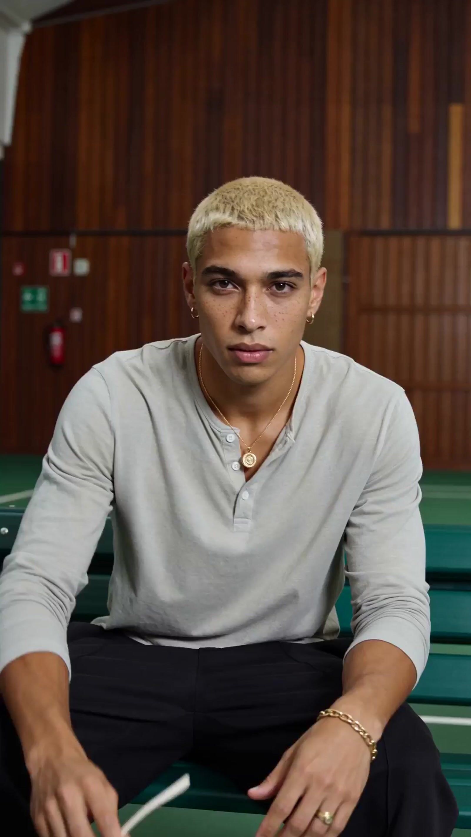 a man sitting on a bench with a cigarette in his mouth