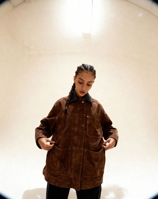 a woman standing in front of a white wall