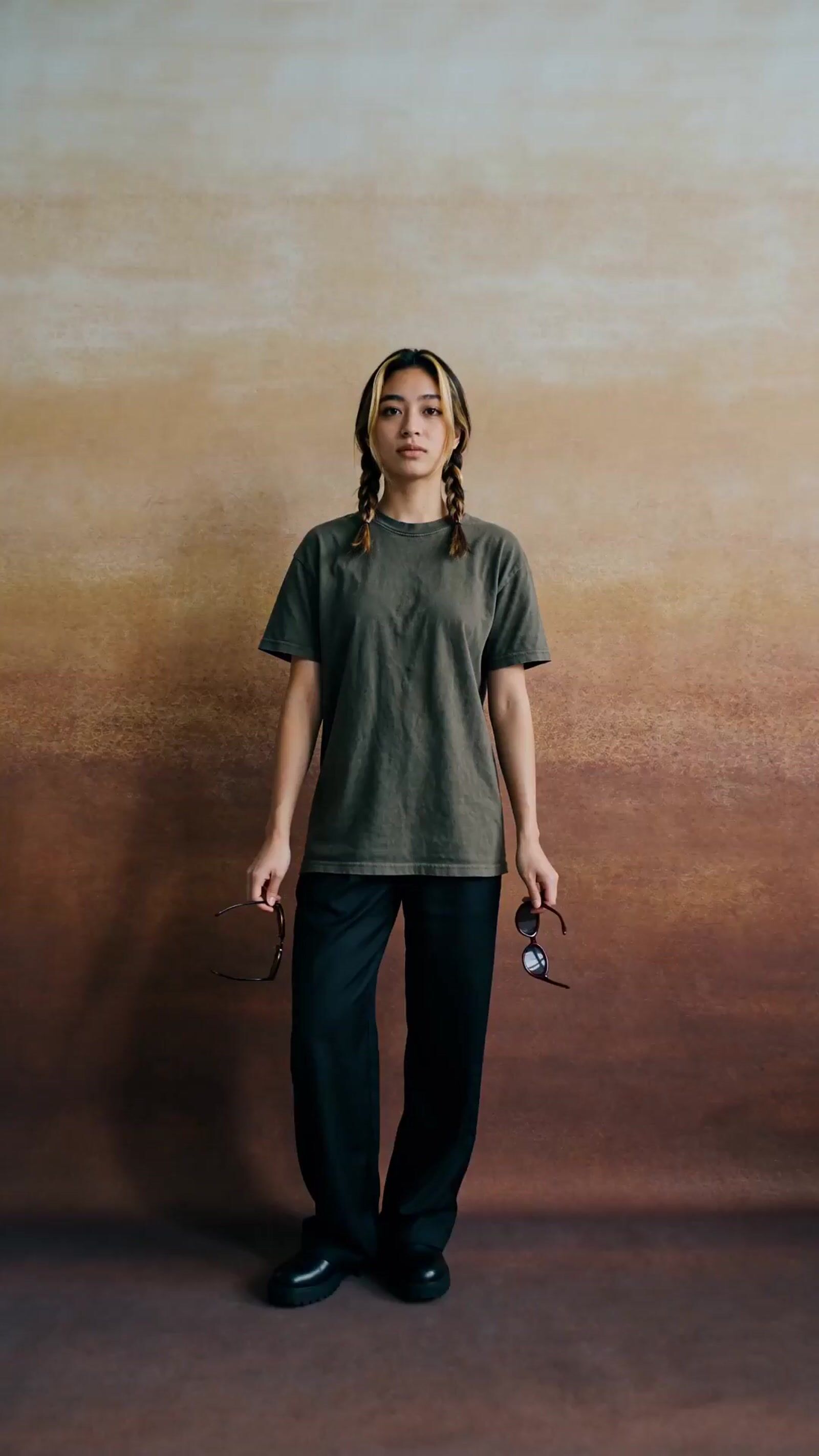 a woman standing in front of a brown wall