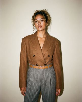 a woman standing in front of a white wall