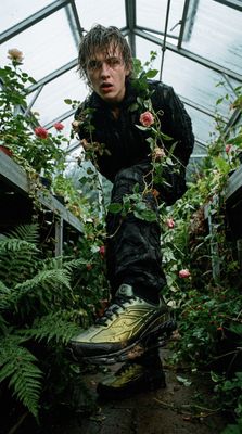 a man in a greenhouse surrounded by plants