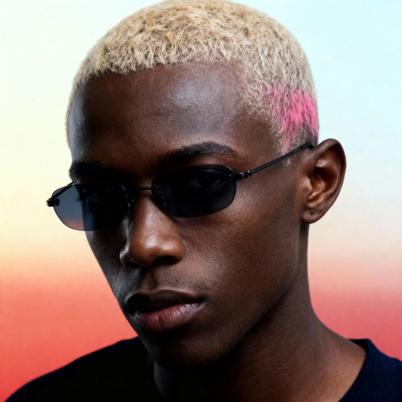 a man with a pink mohawk wearing sunglasses