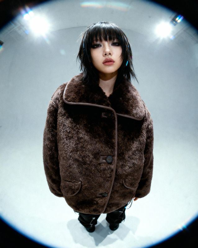 a woman wearing a brown coat and black pants