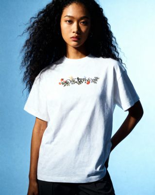 a woman with long hair wearing a white t - shirt