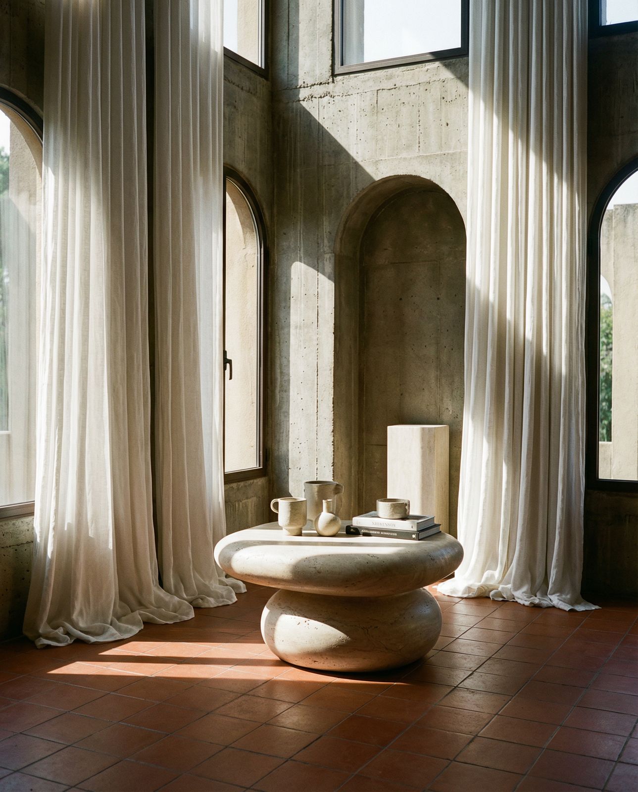 a room with large windows and a table in the middle of the room