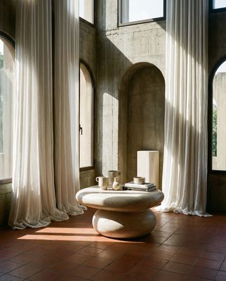 a room with large windows and a table in the middle of the room