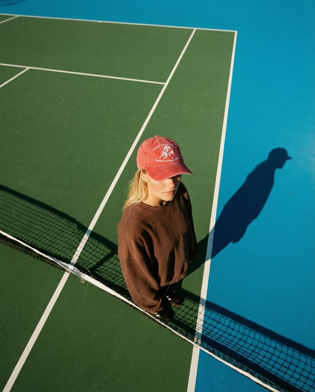 a woman sitting on a tennis court with a racquet