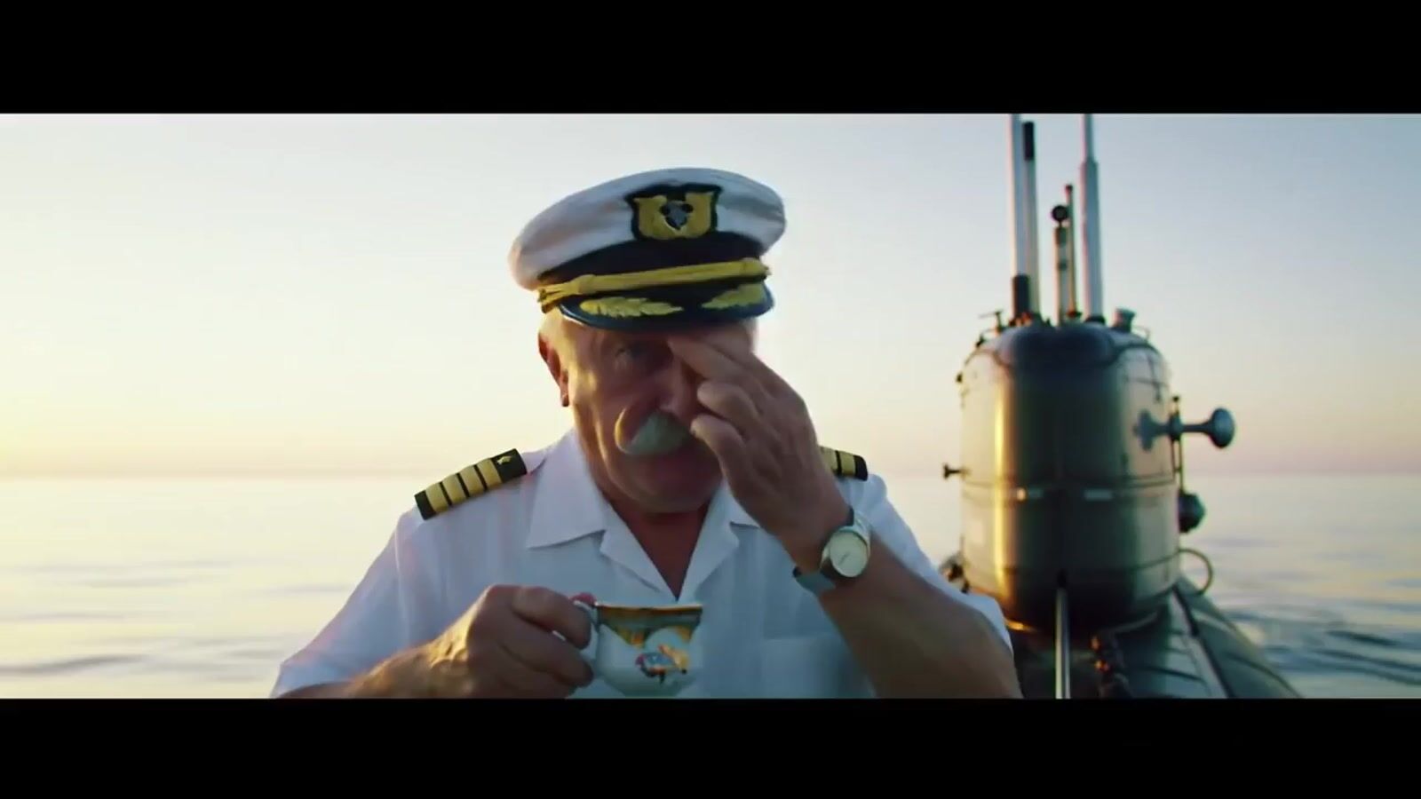 a man in a sailor's uniform eating a piece of food