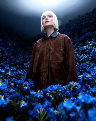 a woman standing in a field of blue flowers